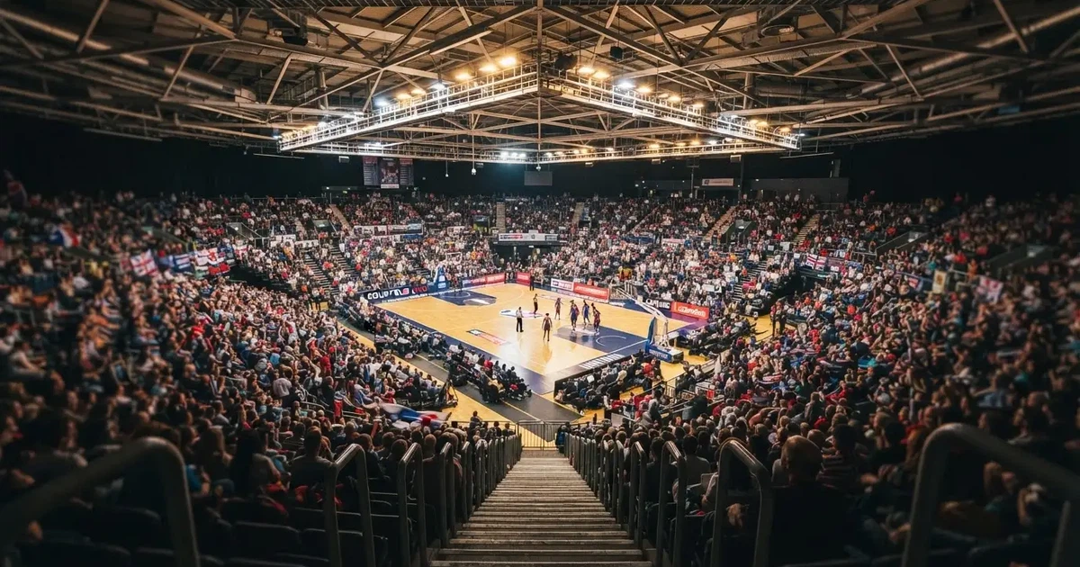 A packed sports hall under floodlights photographed from a long way off