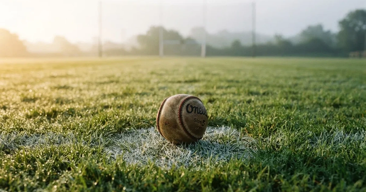 A ball on the centre spot of a grass pitch in morning light