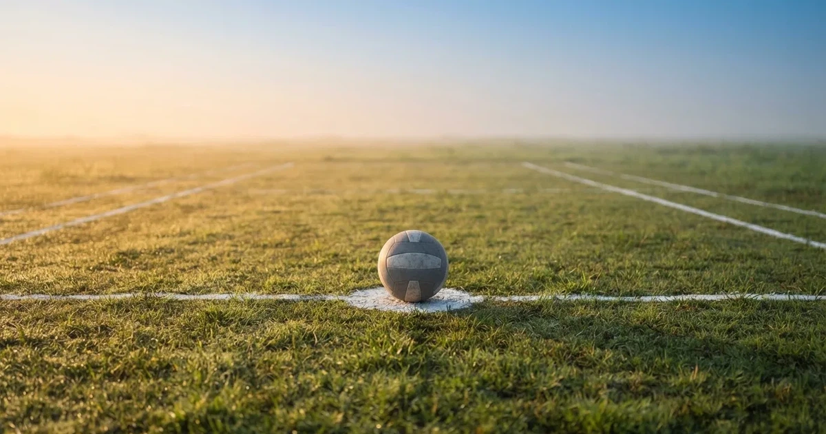A ball on the centre spot of a grass pitch in morning light