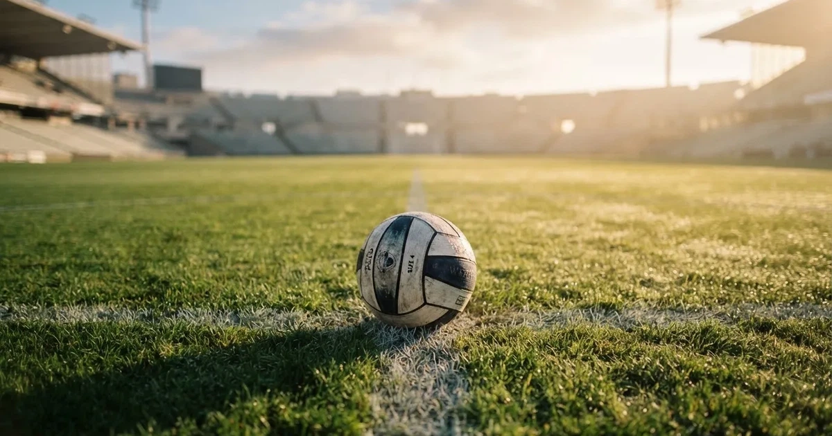 A ball on the centre spot of a grass pitch in morning light