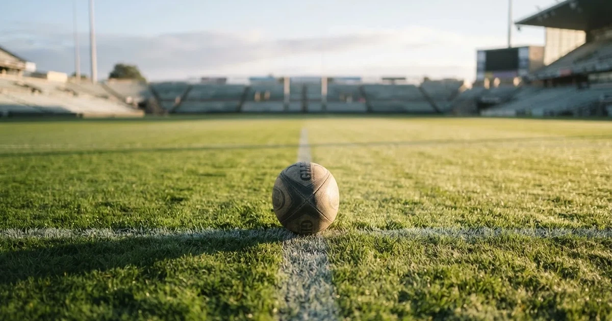 A ball on the centre spot of a grass pitch in morning light