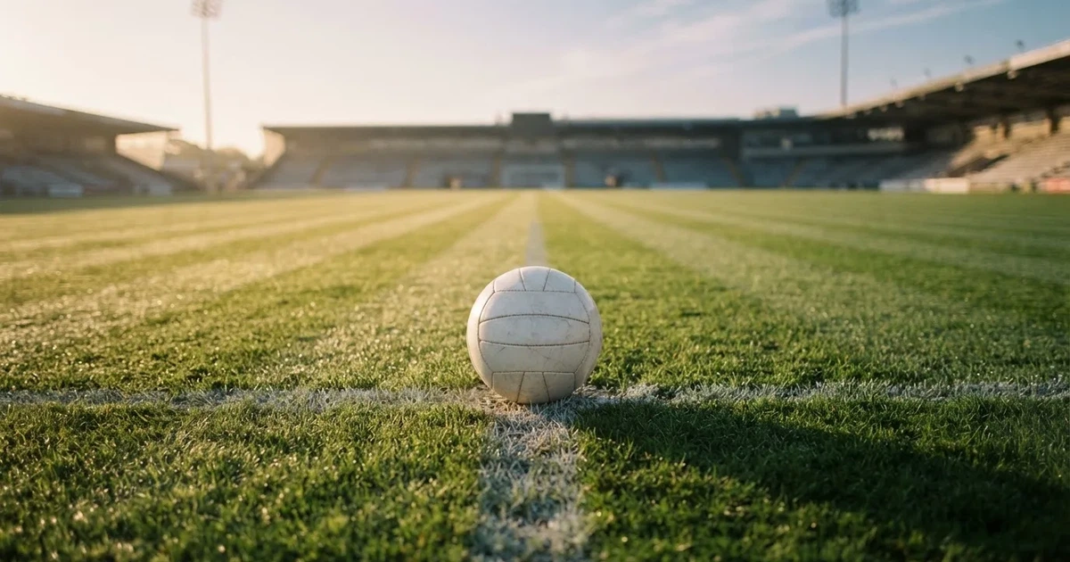 A ball on the centre spot of a grass pitch in morning light